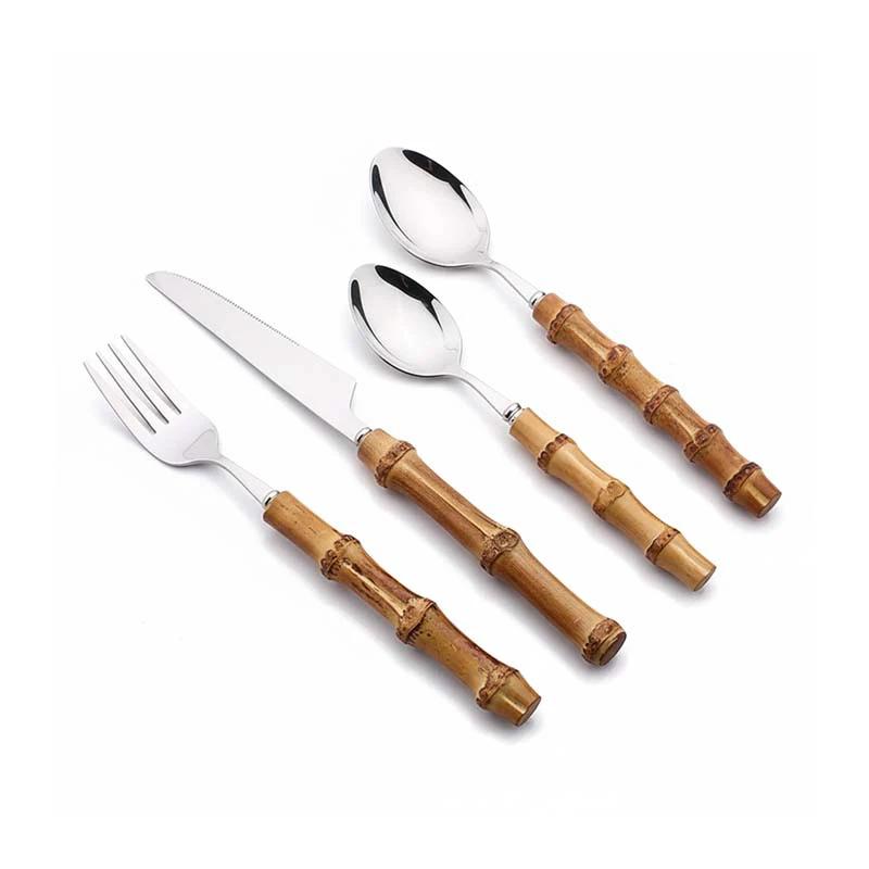 24-Piece Bamboo Handle Cutlery Set with stainless steel flatware laid out on a white surface