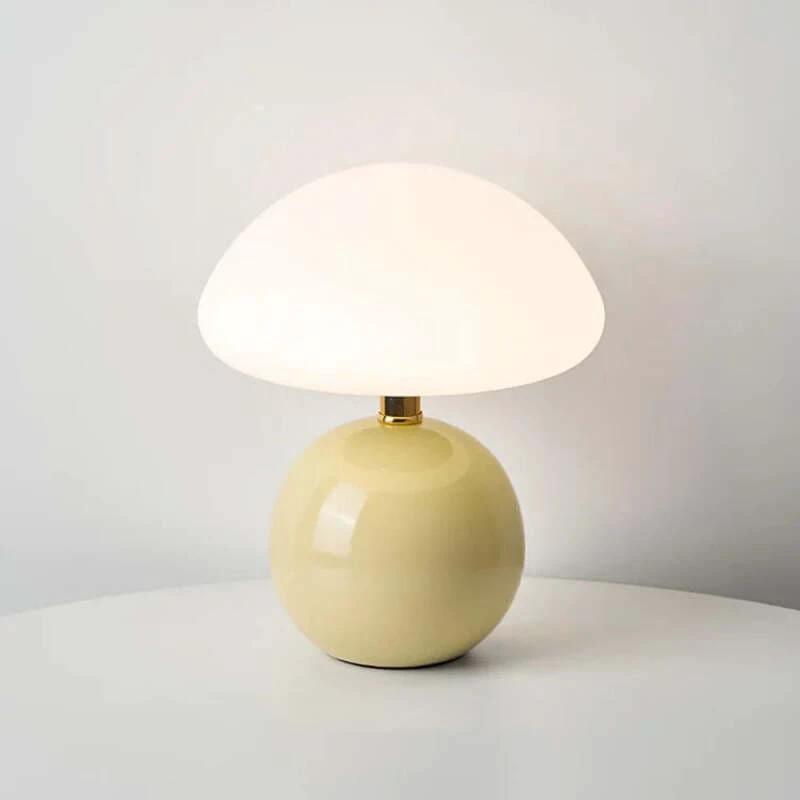 Cream-colored modern ceramic table lamp on a light gray surface with a neutral background
